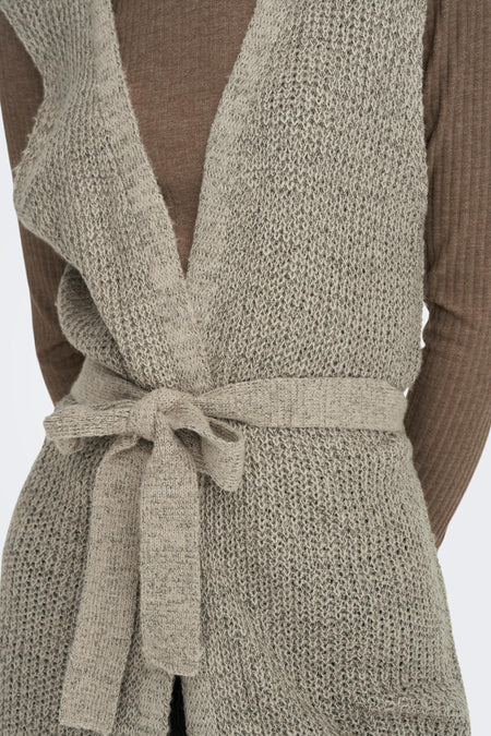 Gilet brun de JDY, tricoté avec une ceinture à la taille et porté sur un haut brun.