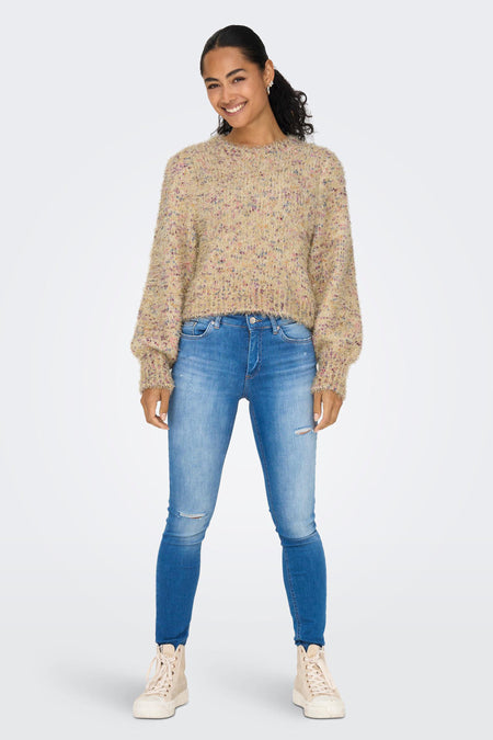 Veste en or ONLY, avec des manches longues et une texture douce et feutrée, portée avec des jeans bleus et des baskets crème.