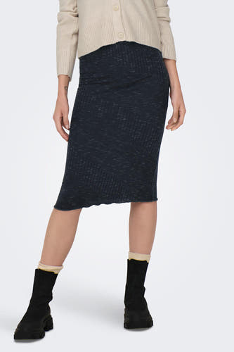 Jupe grise de JDY, avec une texture à fines bretelles et portée avec des bottes noires et un gilet beige.