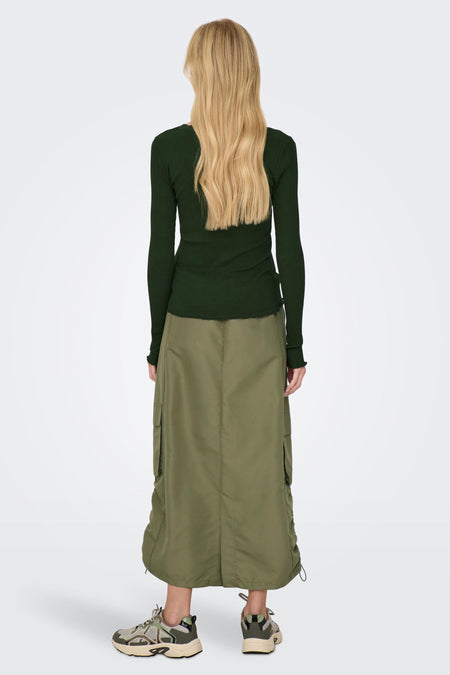 Long manteau brun d'ONLY, avec poches et détails à cordon, associé à une chemise verte foncée et des baskets.