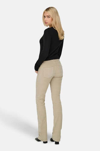 Pantalon beige de ONLY, avec texture corduroy, porté avec un pull noir et des chaussures noires.