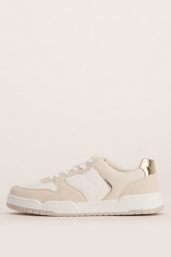 Beige en witte sneaker met gouden details.