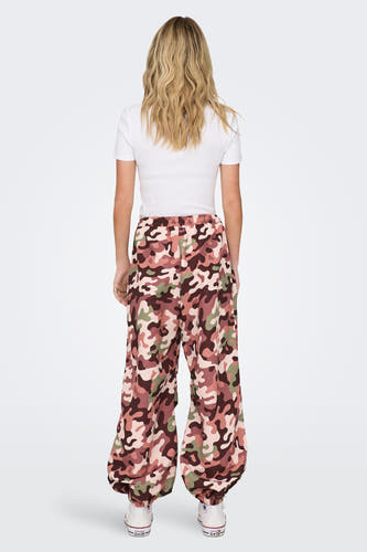 Pantalon camouflage de NEON & NYLON, coupe décontractée, avec un haut blanc et des baskets Converse All Stars.