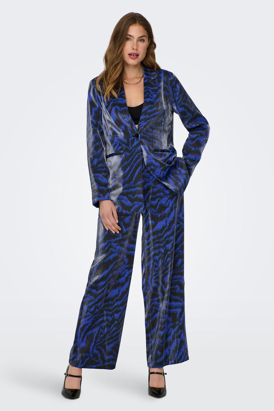Pantalon de costume bleu ONLY, avec un motif zébré frappant et des jambes larges, associé à une veste coordonnée et des baskets noires.