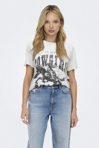T-shirt écru à manches courtes de ONLY, avec une coupe décontractée et porté avec des jeans bleus.