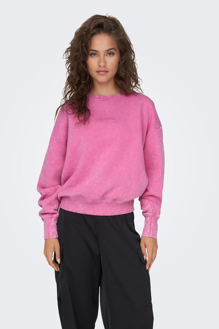 Pull-over rose ONLY, avec des manches longues et un col rond, associé à un pantalon cargo noir.