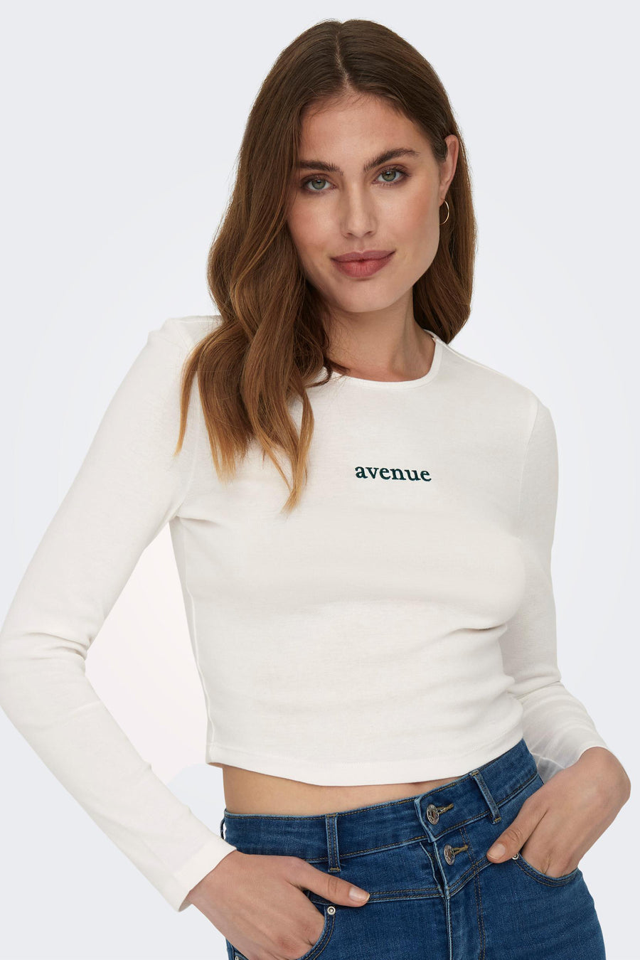 T-shirt blanc à manches longues de ONLY, avec l'écriture 'avenue' bleue, associé à un jean bleu.