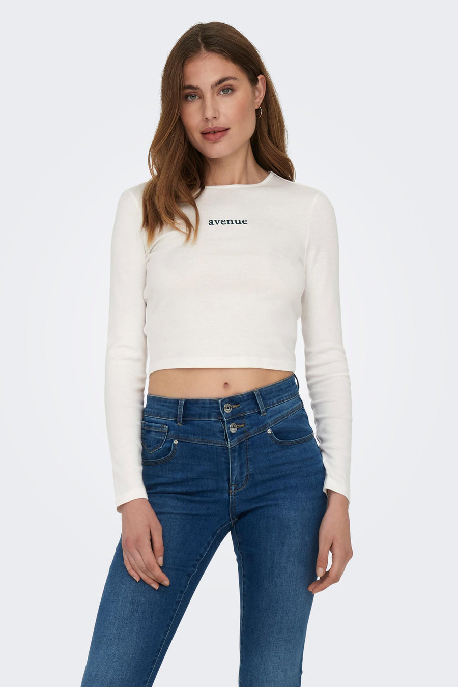 T-shirt blanc à manches longues d'ONLY, avec le texte "avenue" et associé à des jeans bleus.