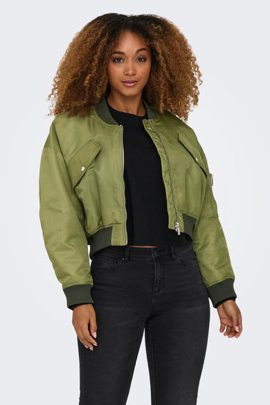 Veste courte verte de ONLY, avec des manches longues et portée avec un jean noir et des bottes noires.