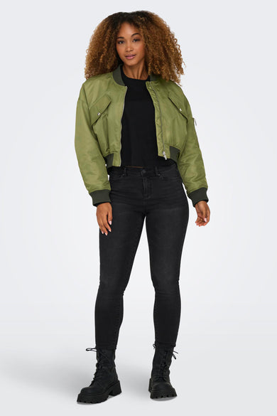 Groene korte jas van ONLY, gedragen met een zwart T-shirt, zwarte jeans en veterlaarzen.
