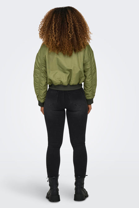 Groene korte jas van ONLY, met lange mouwen en gedragen met een zwarte jeans en zwarte veterboots.
