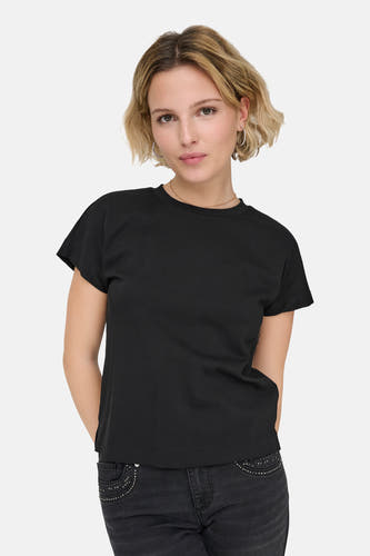 T-shirt noir à manches courtes de ONLY, porté avec une chaîne dorée et un jean noir à poches décorées.