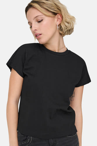 T-shirt noir à manches courtes de ONLY, avec un col rond et porté avec une chaîne dorée.