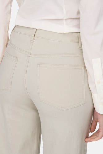 Jeans taille haute en denim écru d'ONLY, avec poches arrière et une blouse de couleur claire.