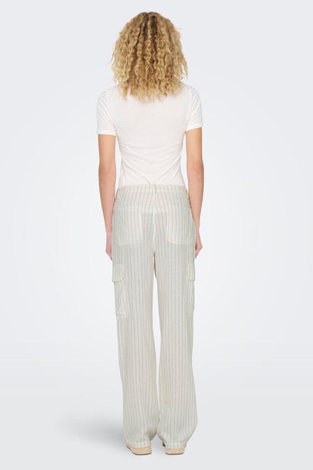 Witte cargobroek van ONLY, met krijtstrepen en zakken op de pijpen, gedragen met een wit shirt en espadrilles.