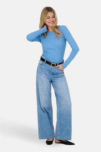 Blauw T-shirt met lange mouwen van JDY, met effen kleur en lange mouwen, gecombineerd met wijde jeans en een zwarte riem.
