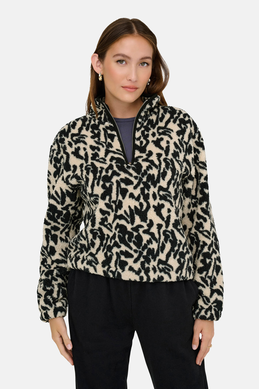 Vrouw met zwart-beige fleece trui en zwarte broek.