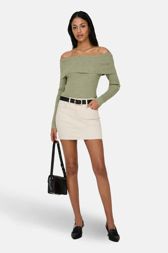 Pull vert épaules dénudées vert de ONLY, à manches longues, combiné avec une jupe de couleur crème, une ceinture noire, un sac à main et des chaussures.