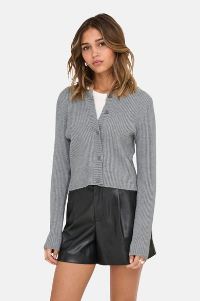 Veste grise d'ONLY, avec fermeture à boutons, portée sur une chemise blanche et associée à des short en cuir noirs.
