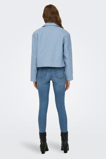 Blauw kort jasje van JDY, met lange mouwen en gecombineerd met jeans en zwarte laarsjes.