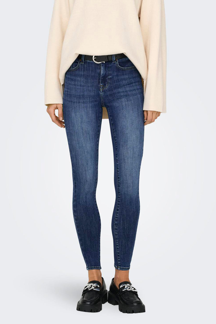 Jean skinny bleu foncé en denim de ONLY®, dos, porté avec un pull clair et des chaussures noires.