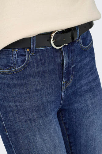 Gros plan sur un jean skinny bleu foncé de la marque ONLY, avec des surpiqûres jaunes, une ceinture noire et une boucle argentée.