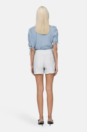 Short blanc ONLY ONLY, une taille taille é é combin combiné avec avec blouse bleu clair et des talons.