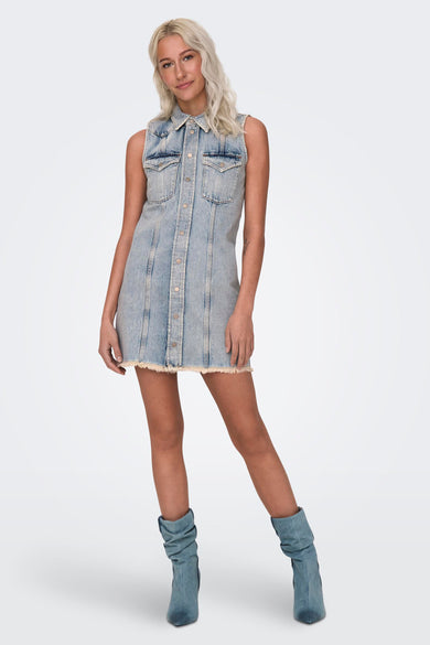 Korte denim jurk in lichtblauw van ONLY, met knoopsluiting en gerafelde zoom, gedragen met blauwe laarzen.
