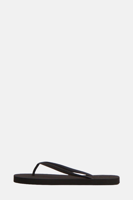 Chaussons noirs ONLY® avec un design minimaliste et une texture sur la semelle.
