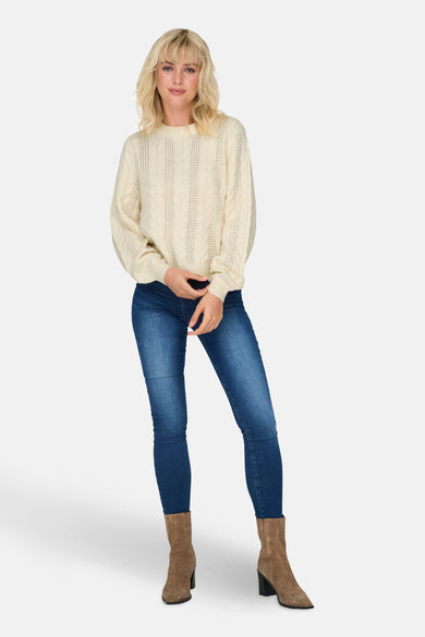 Pull blanc à col rond de ONLY, avec un motif côtelé et porté avec des jeans et des bottes.