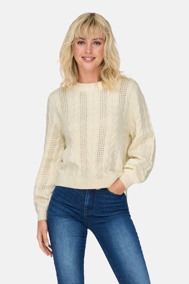 Pull blanc à col rond ONLY®, avec motif côtelé et jeans bleus.