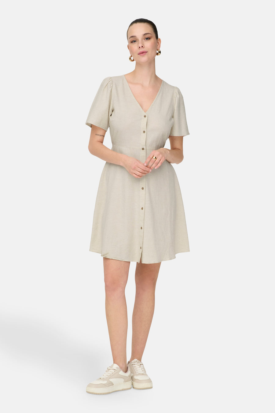 Robe écru à manches courtes de ONLY, avec une fermeture à boutons et portée avec des baskets blanches.