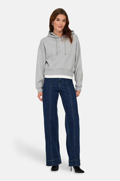 Grijze sweater met kap van ONLY, met trekkoorden en gecombineerd met een blauwe jeans.
