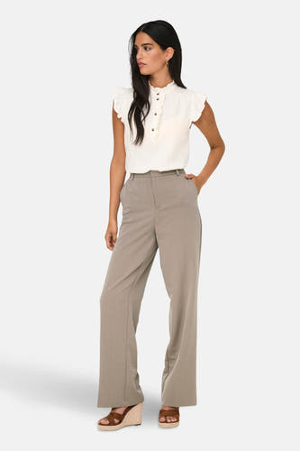 Beige kostuumbroek van ONLY, met wijde pijpen en gestyled met een crèmekleurige blouse en sleehakken.
