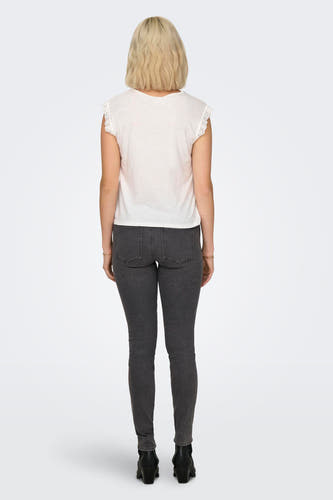 T-shirt blanc à manches courtes de JDY, dos, fini avec des détails en dentelle et combiné avec un jean gris et des bottes noires.