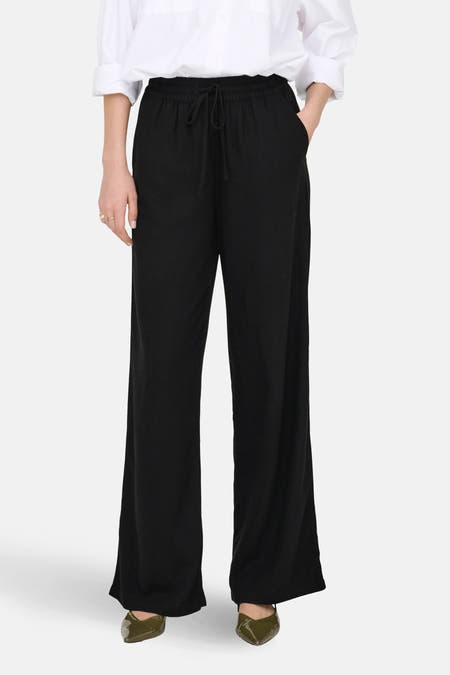 Zwarte broek van JDY, met een elastische tailleband met trekkoord en wijde pijpen.
