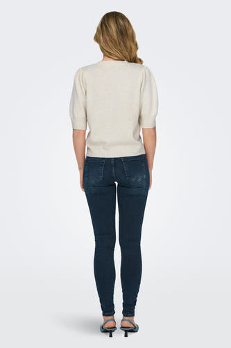 Witte trui van ONLY, met korte pofmouwen, gecombineerd met donkere jeans en blauwe schoenen, gezien van achteren.
