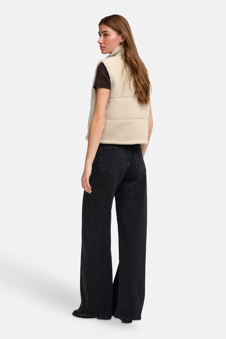 Doudoune sans manches crème en laine de mouton, de la marque ONLY®, avec col arrondi et panneaux rembourrés, vue de dos sur un mannequin portant un jean foncé.