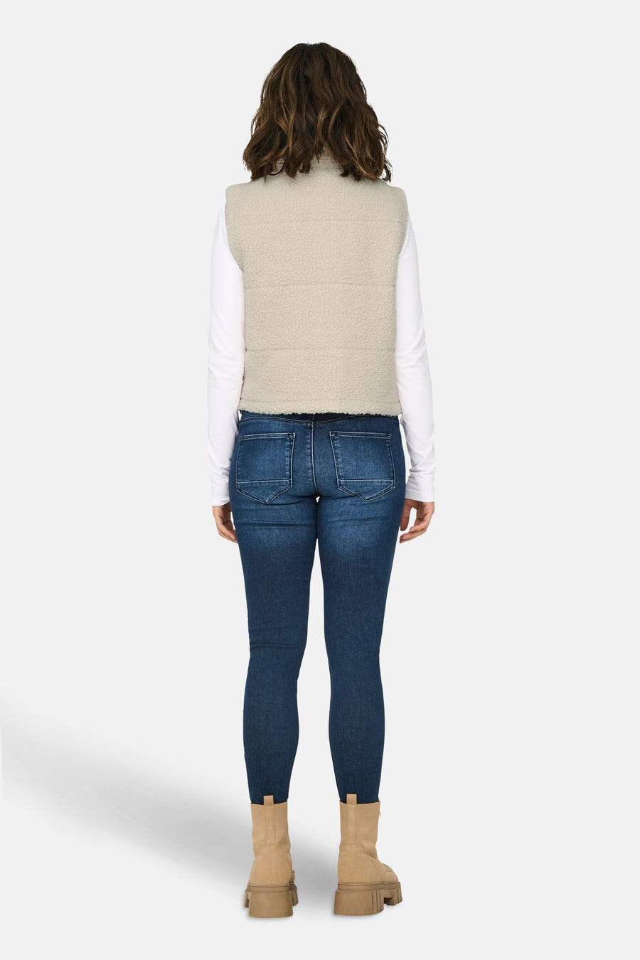 Gilet écru de ONLY, avec texture à carreaux, porté sur un t-shirt blanc et des jeans foncés avec des bottes beige, dos.