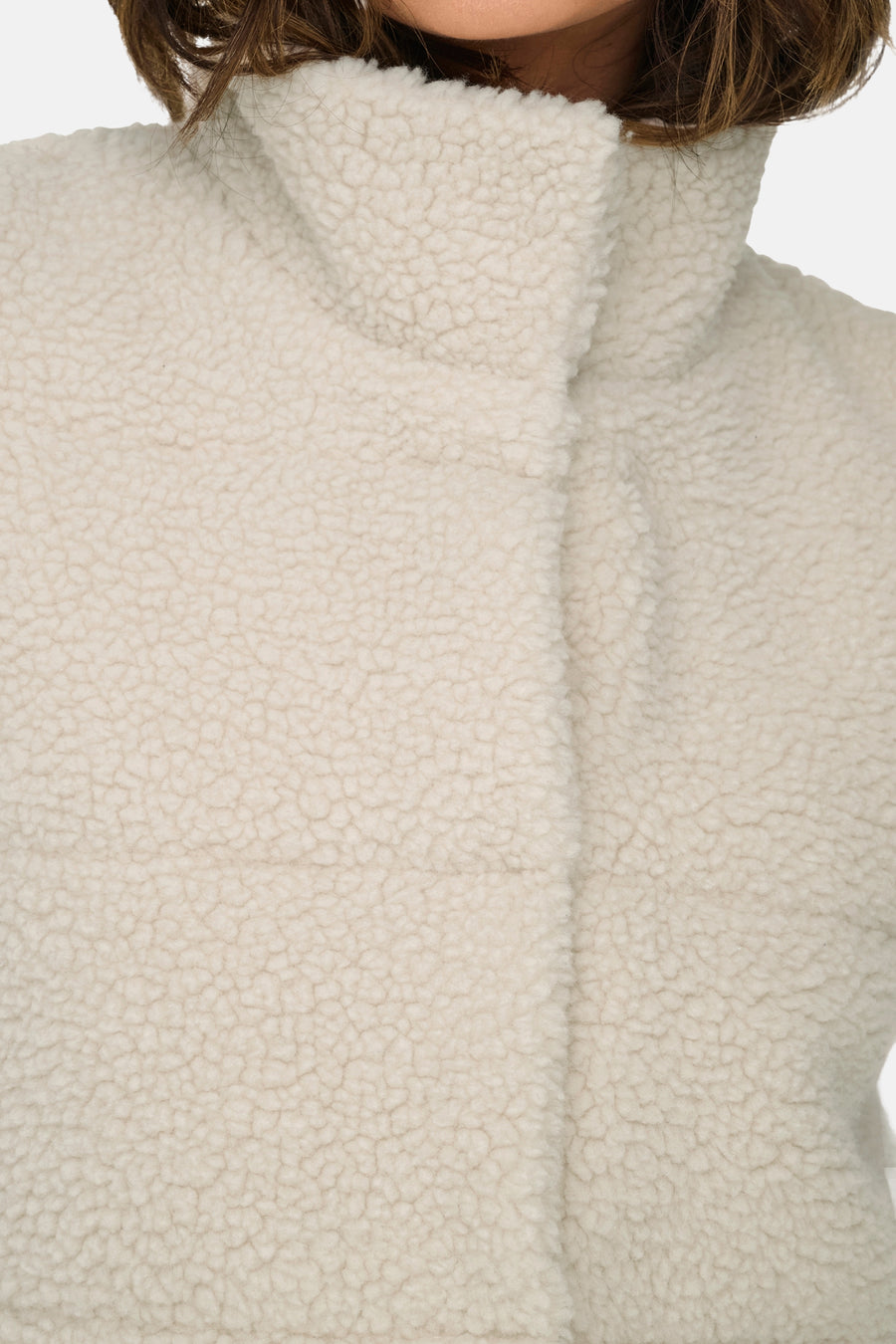 Gilet écru de ONLY, avec un col montant et une douce texture teddy.