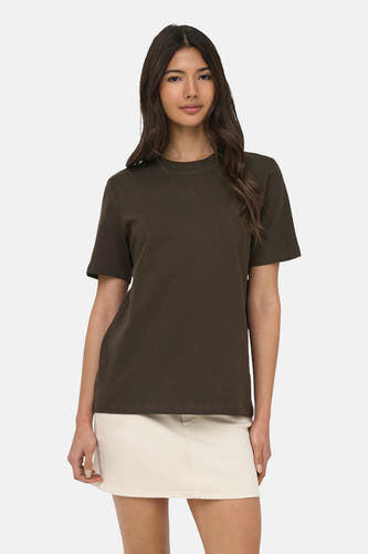 T-shirt marron à manches courtes ONLY®, porté par un mannequin avec une jupe blanc cassé et des tongs à imprimé léopard.