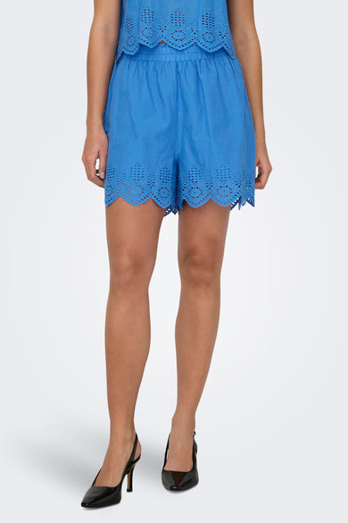 Short bleu ONLY avec des détails ajourés, vu de derrière, combiné avec une top à taille et des bottes noires.