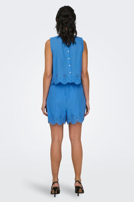 Blauwe short van ONLY met ajourdetails, gezien van achteren, gecombineerd met een bijpassende top en zwarte hakken.