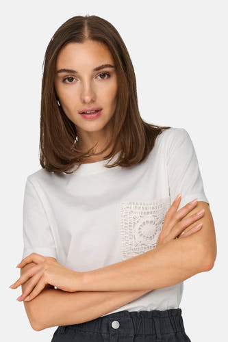T-shirt blanc à manches courtes de JDY, avec détail de poche en dentelle et bras croisés.