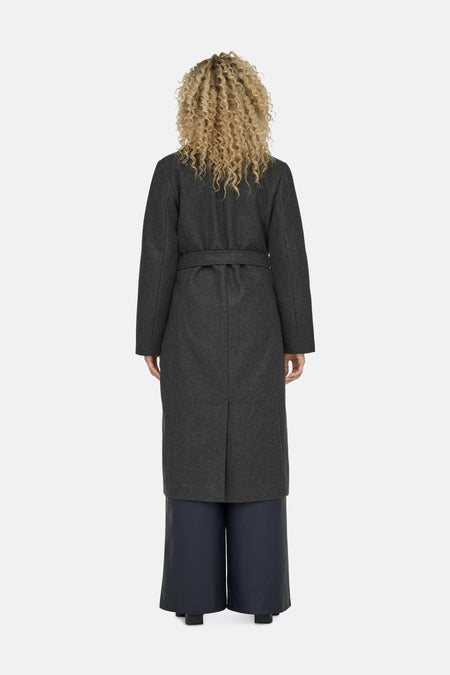 Manteau gris d'ONLY, vu de derrière, avec une ceinture et un pantalon foncé.