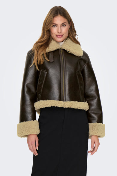 Manteau court brun d'ONLY®, avec col en fourrure synthétique et porté sur une jupe noire.