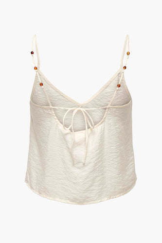 Ivoorwit satijnen top met kraalbandjes en striksluiting.