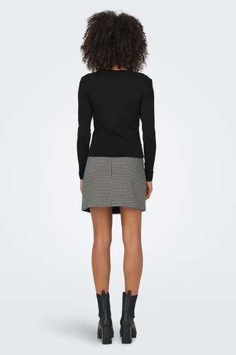T-shirt noir à manches longues de ONLY, associé à une jupe houndstooth et des bottes noires.