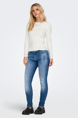 Ecru T-shirt met lange mouwen van ONLY, gedragen met een zilveren ketting, jeans met gaten en zwarte schoenen.