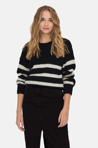 Pull-over noir à col rond de ONLY, avec des rayures blanches et des manches longues, associé à une jupe noire et des bottes.
